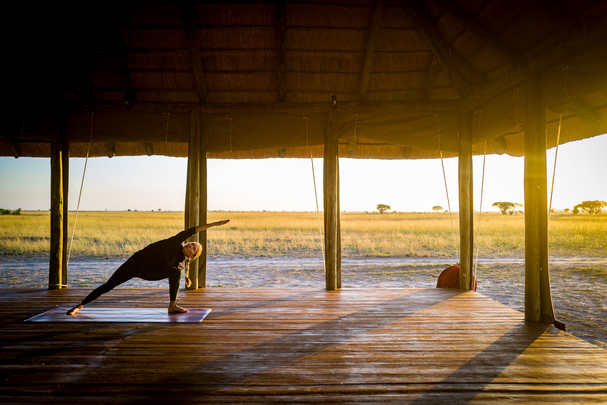 Practicing yoga on the shala deck at sunset, overlooking the savannah.